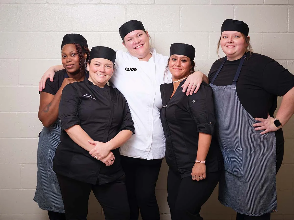 A group of employees standing together smiling