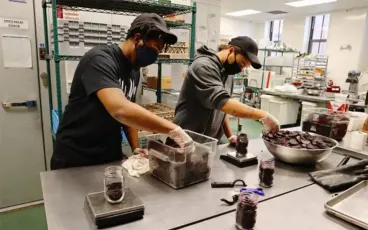 Community members preparing food together in a kitchen